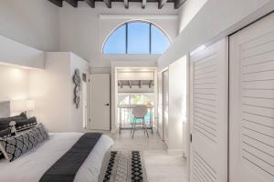 a bedroom with a bed and a window and a table at Villa at St James Unit A Luxury Pool Villa, Pet Friendly in Miami