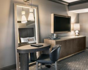 a room with a desk and a tv and a mirror at The Phoenician, a Luxury Collection Resort, Scottsdale in Scottsdale