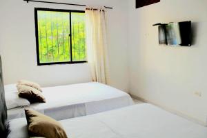 1 dormitorio con 2 camas y ventana en H B SULTAN SUITE en Cartagena de Indias