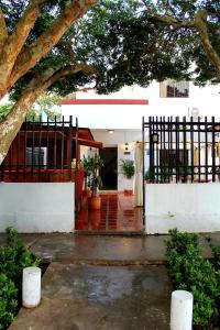 una casa blanca con una puerta y un árbol en H B SULTAN SUITE, en Cartagena de Indias