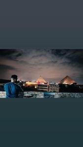 a man sitting on a wall looking at a city at Falcon pyramids inn in Cairo