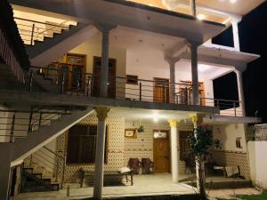 a large house with a balcony and stairs at Finger Peak Hotel in Kalām