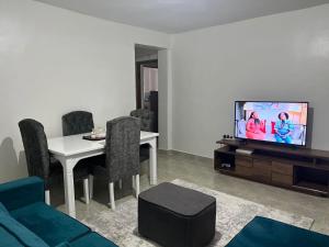 a living room with a television and a table and chairs at Serene cozy homes Kericho in Kericho