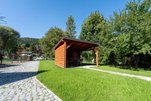 un pequeño cobertizo en el césped junto a una carretera en Ski & Sauna House - 400 m do stoku - dom dla 8os - Dream Apart en Szczyrk