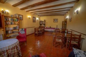 a dining room with a table and chairs and bookshelves at Pension Las Cuevas de Cañart in Las Cuevas de Cañart