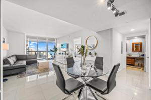 マイアミにある*ICONIC W ICON CONDO/ POOL&WATERVIEWS*FREESPA*のガラスのテーブルと椅子のあるリビングルーム