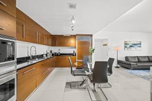 マイアミにある*ICONIC W ICON CONDO/ POOL&WATERVIEWS*FREESPA*のテーブルと椅子のあるキッチンとリビングルーム