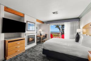 una camera d'albergo con letto, TV e camino di Beachcomber Motel a Fort Bragg