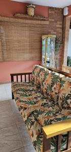 um sofá sentado numa sala de estar com um padrão de flores em CASA DA ZEZÉ Pousada & Hotel ITABORAÍ em Itaboraí