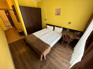 a small bedroom with a bed and a table at Готель Цісар in Lviv