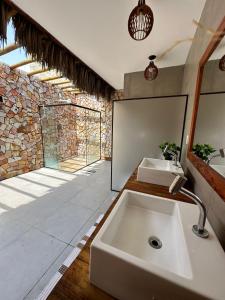 La salle de bains est pourvue d'un lavabo et d'une grande fenêtre. dans l'établissement Bangalô com piscina privativa em Barra Grande/Pi, à Barrinha