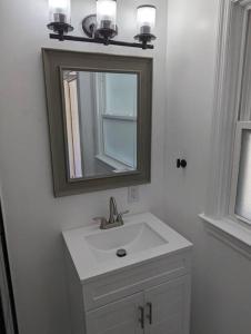 a bathroom with a sink and a mirror at Newly Renovated Studio - Close to WakeMed Raleigh in Raleigh