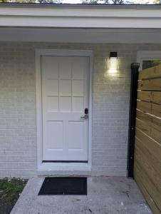 a white garage door on a brick house at Newly Renovated Studio - Close to WakeMed Raleigh in Raleigh
