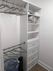 a closet with white drawers and a shelf at Newly Renovated Studio - Close to WakeMed Raleigh in Raleigh