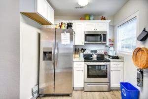 a kitchen with a stainless steel refrigerator and white cabinets at Hampton Home with Grill Less Than 1 Mi to Beach! in Hampton +16 photos