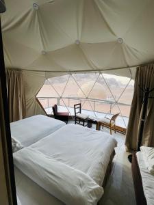 a bedroom with a tent with a table and chairs at RUM iSLAND LUXURY CAMP in Wadi Rum