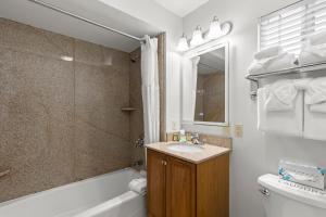 a bathroom with a sink and a tub and a toilet at Beachcomber Motel in Fort Bragg +49 photos