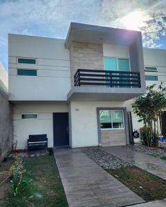 Cette maison blanche dispose d'un balcon. dans l'établissement Palmeira71, acogedora Casa en Privada de ValleAlto, à Bellavista