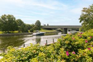 ein Boot auf einem Fluss mit einer Brücke im Hintergrund in der Unterkunft Sonder The O'Connor in Ottawa