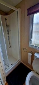 La salle de bains est pourvue d'une douche et de toilettes. dans l'établissement 3 bedroom caravan, à Kinmel Bay