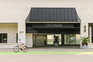 a person riding a bike in front of a store at Sonder The O'Connor in Ottawa