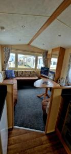 - un salon avec un canapé et une table dans l'établissement 3 bedroom caravan, à Kinmel Bay