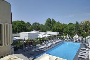 Luftaufnahme eines Pools mit Stühlen und Tischen und einem Gebäude in der Unterkunft Hotel Continental in Timişoara