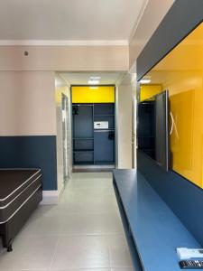 a room with a kitchen with yellow and blue walls at Spazzio Diroma - Hospedagem com Acqua Park (Parque do Vulcão) in Caldas Novas