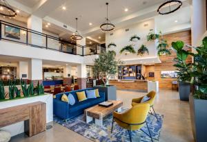 eine Lobby mit einem blauen Sofa und gelben Stühlen in der Unterkunft Ayres Hotel Rialto Fontana in Rialto