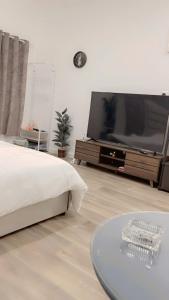 a bedroom with a large television and a coffee table at حائل النقره in Hail