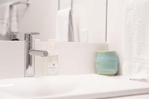 a bathroom with a sink with a bottle of soap at Wildflower Retreat by Revelstoke Vacations in Revelstoke +14 photos