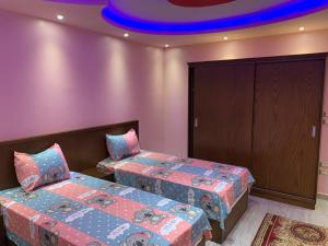 a bedroom with two beds and a blue ceiling at Osama Fwaz in Cairo