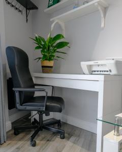 czarne biurowe krzesło siedzące przy biurku z rośliną w obiekcie Luxury one bedroom guesthouse M6, Junction 10 Walsall w mieście Willenhall
