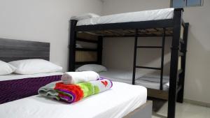 a bedroom with two bunk beds with towels on the bed at HOTEL DASANTO HD in Barranquilla