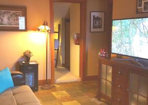 a living room with a couch and a flat screen tv at Cottage on the Mississippi Venue and dog friendly in Le Claire