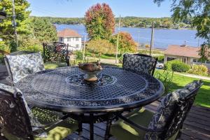 una mesa negra con sillas y una mesa con vistas al agua en Cottage on the Mississippi Venue and dog friendly en Le Claire