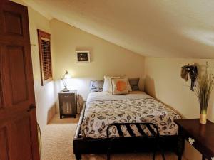 1 dormitorio con 1 cama y 1 mesa con lámpara en Cottage on the Mississippi Venue and dog friendly en Le Claire