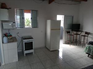 een keuken met een koelkast en een tafel met stoelen bij Recanto da paz 2 in Solemar