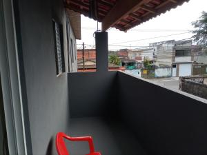 einen roten Stuhl auf einem Balkon mit Aussicht in der Unterkunft Recanto da paz 2 in Solemar