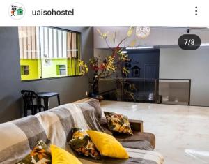 a living room with a couch with pillows on it at Uai Só Hostel in Belo Horizonte