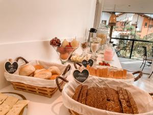 uma mesa coberta com cestas de pão e pastelaria em Pousada Solar dos Lírios - Praia do Rosa na Praia do Rosa