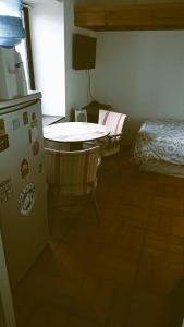 a kitchen with a refrigerator and a table and a bed at Departamento Reñaca Quinto Sector en calle Bellavista in Viña del Mar