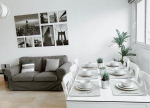 a white living room with a table and a couch at Luxe Living Spacious Retreat Torre Real Ii in Santiago de los Caballeros