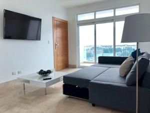 a bedroom with a bed with a table and a flat screen tv at Luxe Living Spacious Retreat Torre Real Ii in Santiago de los Caballeros