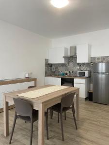 a kitchen with a wooden table and chairs in it at IL TRAMONTO in Montalcino