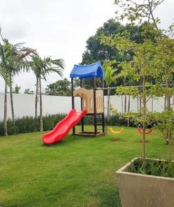 a playground with a red slide and a blue roof at Luxe Living Spacious Retreat Torre Real Ii in Santiago de los Caballeros