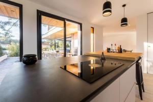 una cocina abierta con una gran isla en una casa en SPRING KEYWEEK - Contemporary villa with pool in the hea, en Anglet
