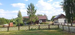una casa con una valla delante de un patio en Podlaski Zakątek, en Bereżyszcze