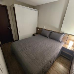 a bedroom with a bed and two lamps and a door at Flat Premiere in Rio de Janeiro