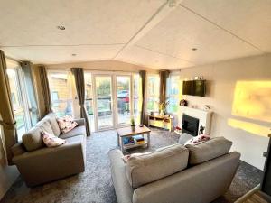 a living room with two couches and a fireplace at Lone Star Lodge in Morpeth